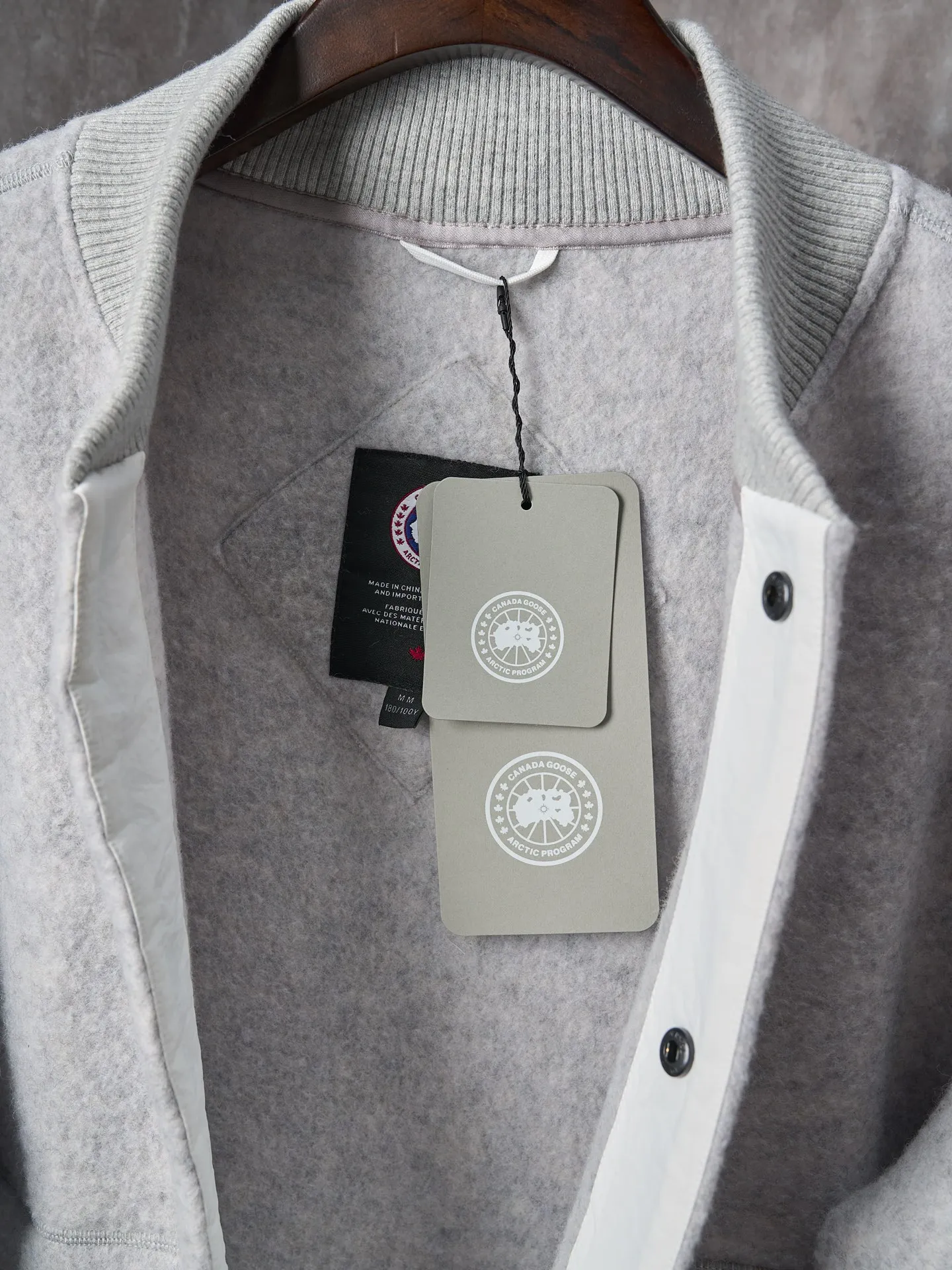 P760 Actual hanging auction] Canada Goose/Canada Goose Fleece Badge Button Cashmere Jacket [Color] Dark Gray Light Gray [Size] S M L XL Wool Blend Fabric: The main fabric of this jacket is light gray wool blend fabric to improve the wear resistance, wrinkle resistance and warmth of the fabric. Wool provides good warmth and a natural feel, while blended fibers enhance the fabric's practicality and durability.  RIBBED KNIT: The collar, cuffs and hem are ribbed knitted for added stretch and fit.  The cutting process needs to ensure that the texture and color of the fabric are evenly distributed, especially with this light gray tone, to avoid chromatic aberrations. The stretchability of wool-blend fabrics needs to be taken into consideration when cutting pieces to ensure dimensional stability of the finished garment.      Use a sewing needle and thread suitable for wool-blend fabrics to avoid damage to the fabric during sewing. The sewing stitches are even and firm to prevent thread stripping.      The temperature needs to be controlled during ironing to avoid high temperature damage to the fabric while keeping the fabric smooth and crisp.   The front and back body parts, sleeves and other main parts are stitched with flat seams to ensure a smooth silhouette.   Align the fabric texture at the splices to keep the look neat.     Details such as pockets and cuffs are designed with inset pockets to increase practicality and aesthetics.     The splicing areas are reinforced to improve durability.  The white circular armband on the left arm is an important part of the brand identity and is finely sewn to ensure it is strong and flat.